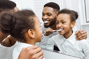 Father and child brushing teeth together