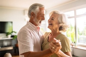 Happy older couple dancing at home