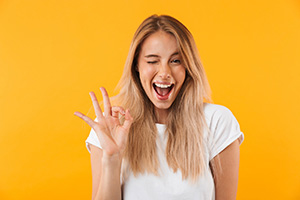 Happy woman using hand to make OK sign