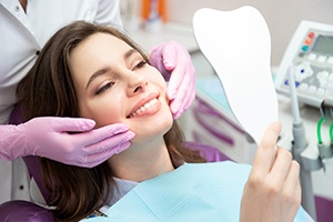 Cosmetic dentistry patient, holding mirror and smiling