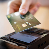 hand holding payment card close to card reader