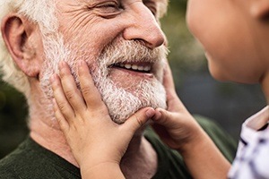 Man with dentures smiling at a child