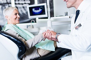 Senior dental patient shaking hands with dentist