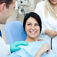 Woman smiling at dentist after toothache treatment