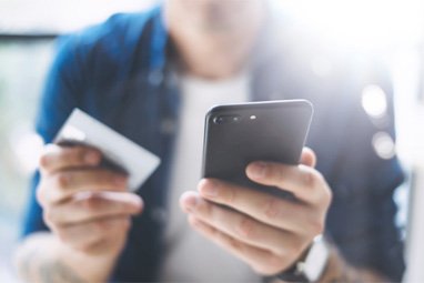 Man holding payment card and smartphone