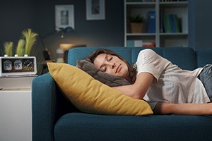 Woman napping on couch after dental procedure