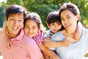 Family of four smiling after dental services