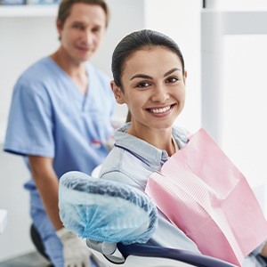 Woman in dental chair smiling after dental hygiene and teeth cleaning visit