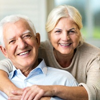 Smiling senior couple with attractive, healthy smiles with dental implants