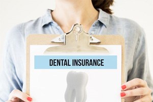 Woman holding clipboard with dental insurance information