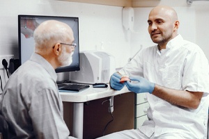 Dentist and patient discussing candidacy for implant dentures