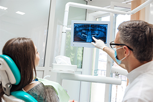 Dentist and patient looking at x-rays during dental implant consultation
