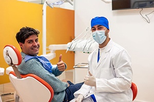 Dentist and patient making thumbs-up gesture