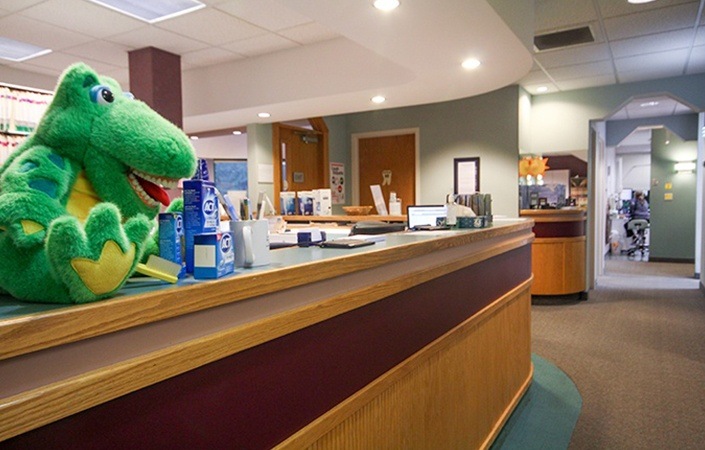 Plush dinosaur toy on dental office reception desk