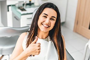 Woman giving thumbs up after oral cancer screening