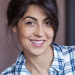 Smiling young woman with traditional orthodontics