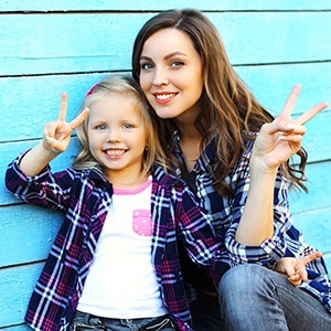 Mother and daughter smiling together after children's dentistry visit