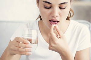 Woman taking oral conscious dental sedation pill