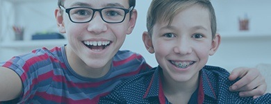 Two smiling kids with orthodontics