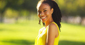 smiling woman with a green backdrop