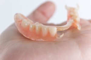 hand holding partial denture