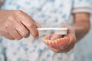 Senior person preparing to brush their dentures