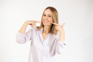Beautiful woman pointing at her teeth