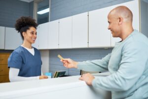Dental team member assisting patient at front desk 