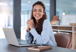 Smiling young professional woman sitting at desk