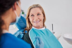Happy senior patient looking at her dentist
